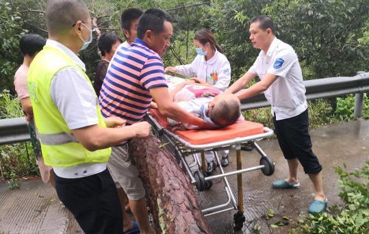 图为：村干部抱着突发脑中风的村民到急救车 何良达 摄