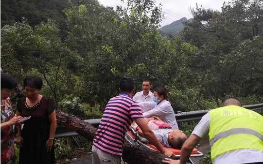 图为：村干部抱着突发脑中风的村民到急救车 何良达 摄